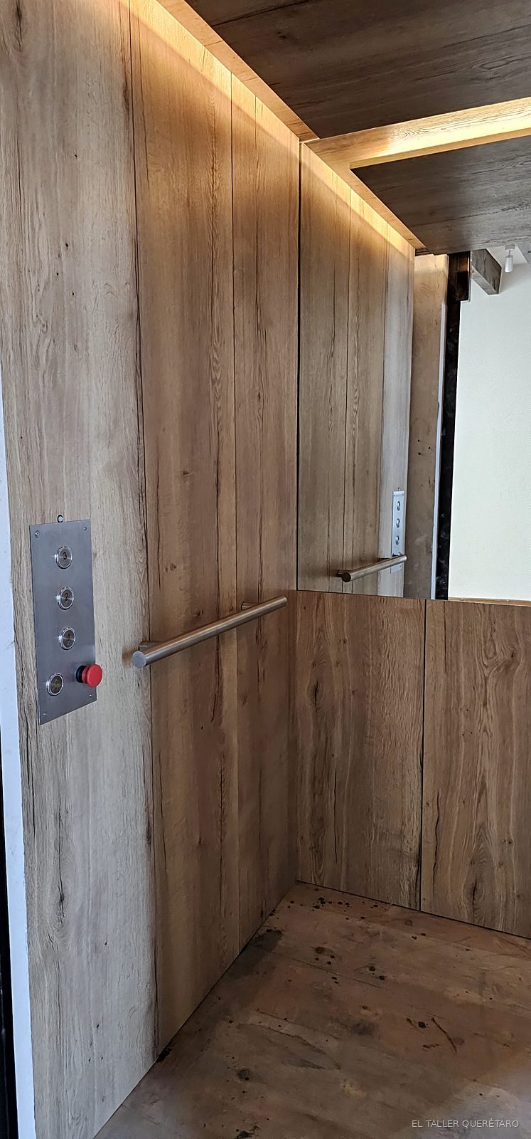 Elevador forrado en madera con botonera y pasamanos