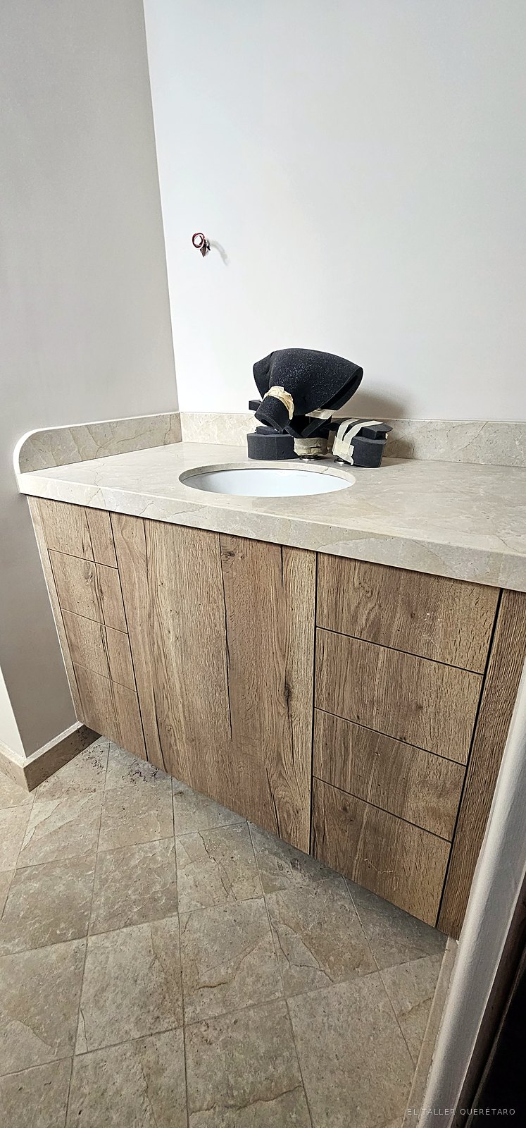 Mueble de baño en roble rústico con cajoneras y cubierta de mármol