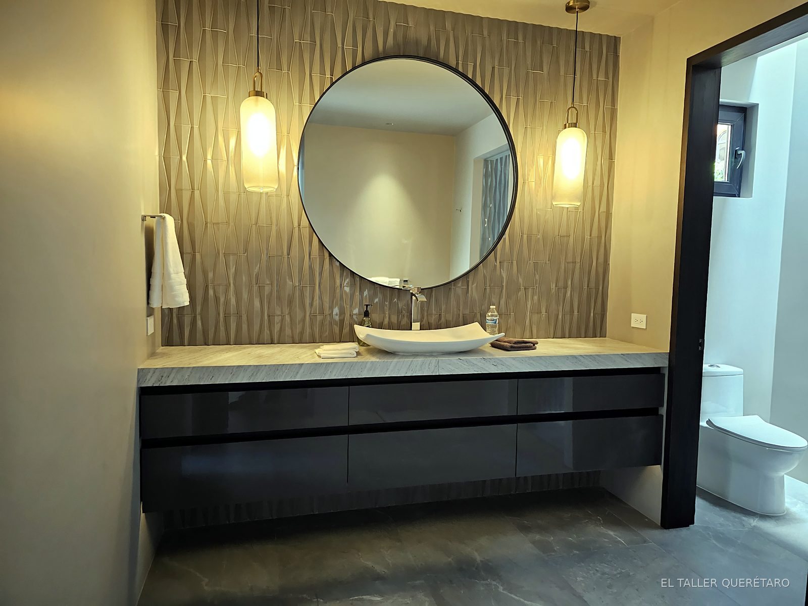 Baño con espejo redondo y mueble flotante