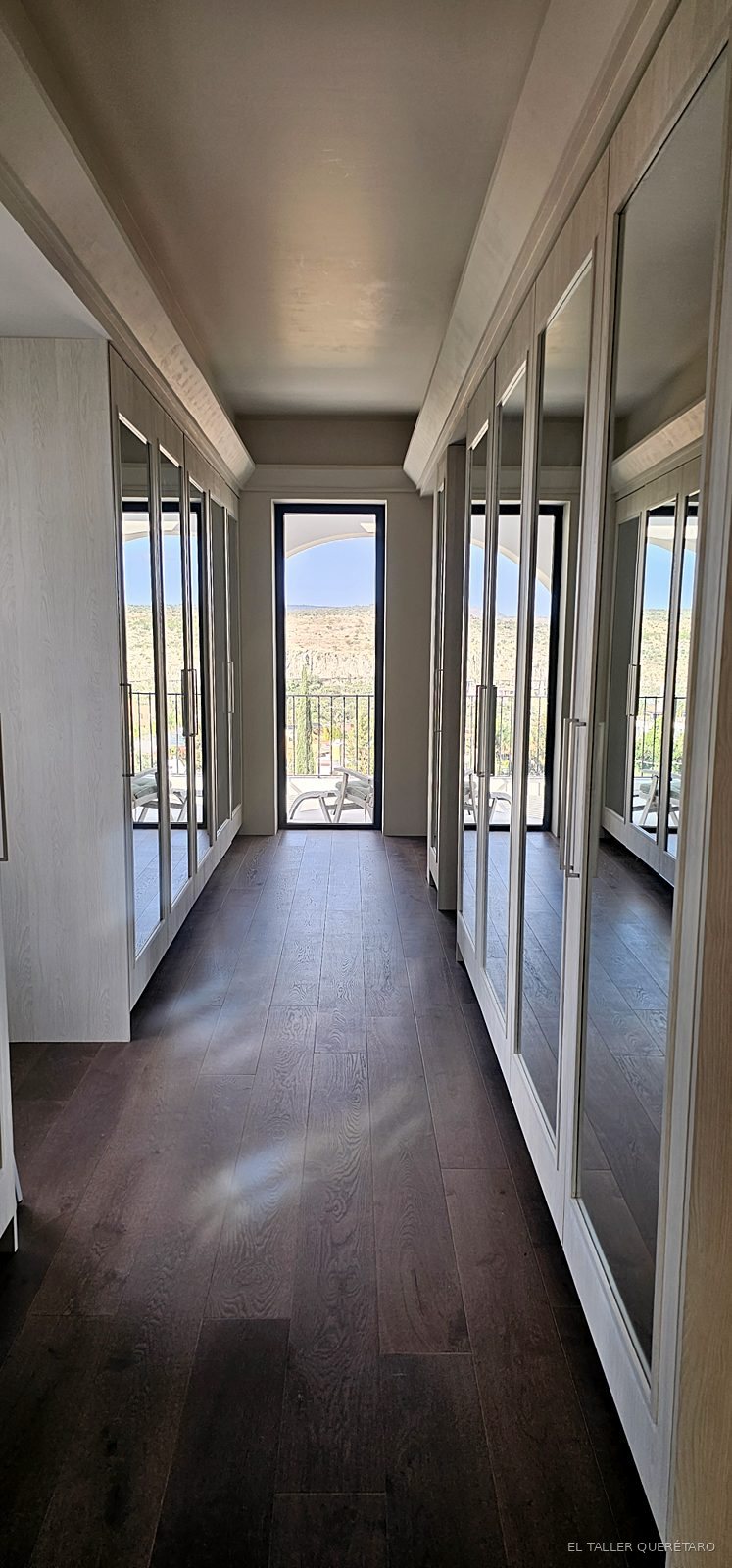 Pasillo con closets de espejo hacia la terraza