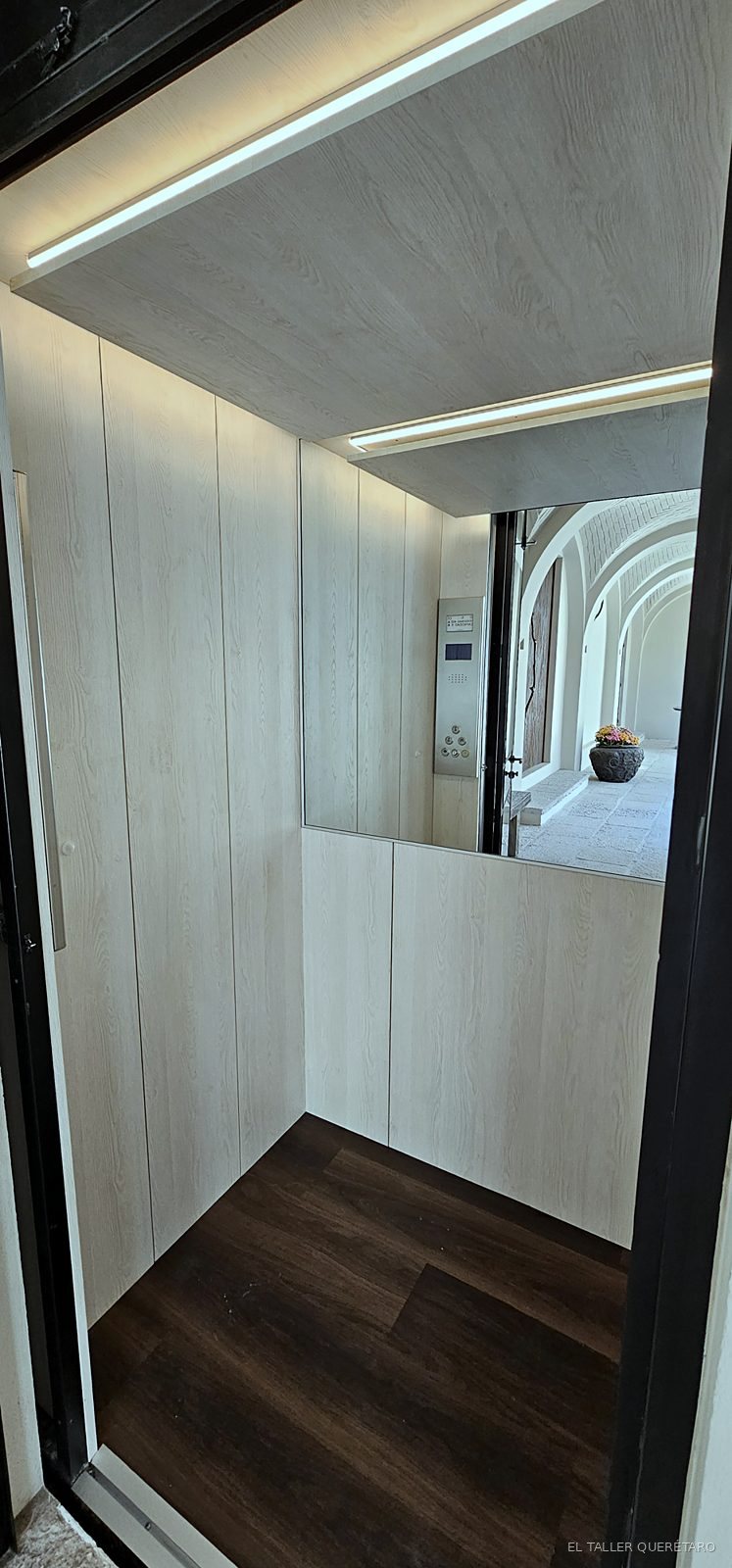 Elevador forrado en madera con luz LED en plafón