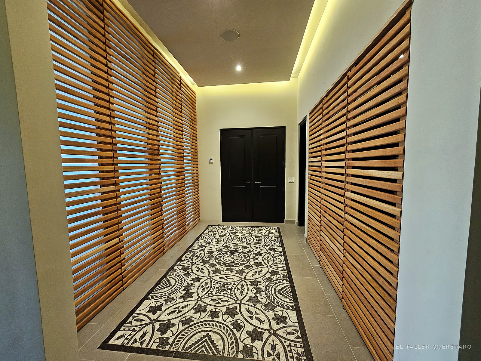 Pasillo con celosías de listones de caoba y piso de mosaico, proyecto La Quinta