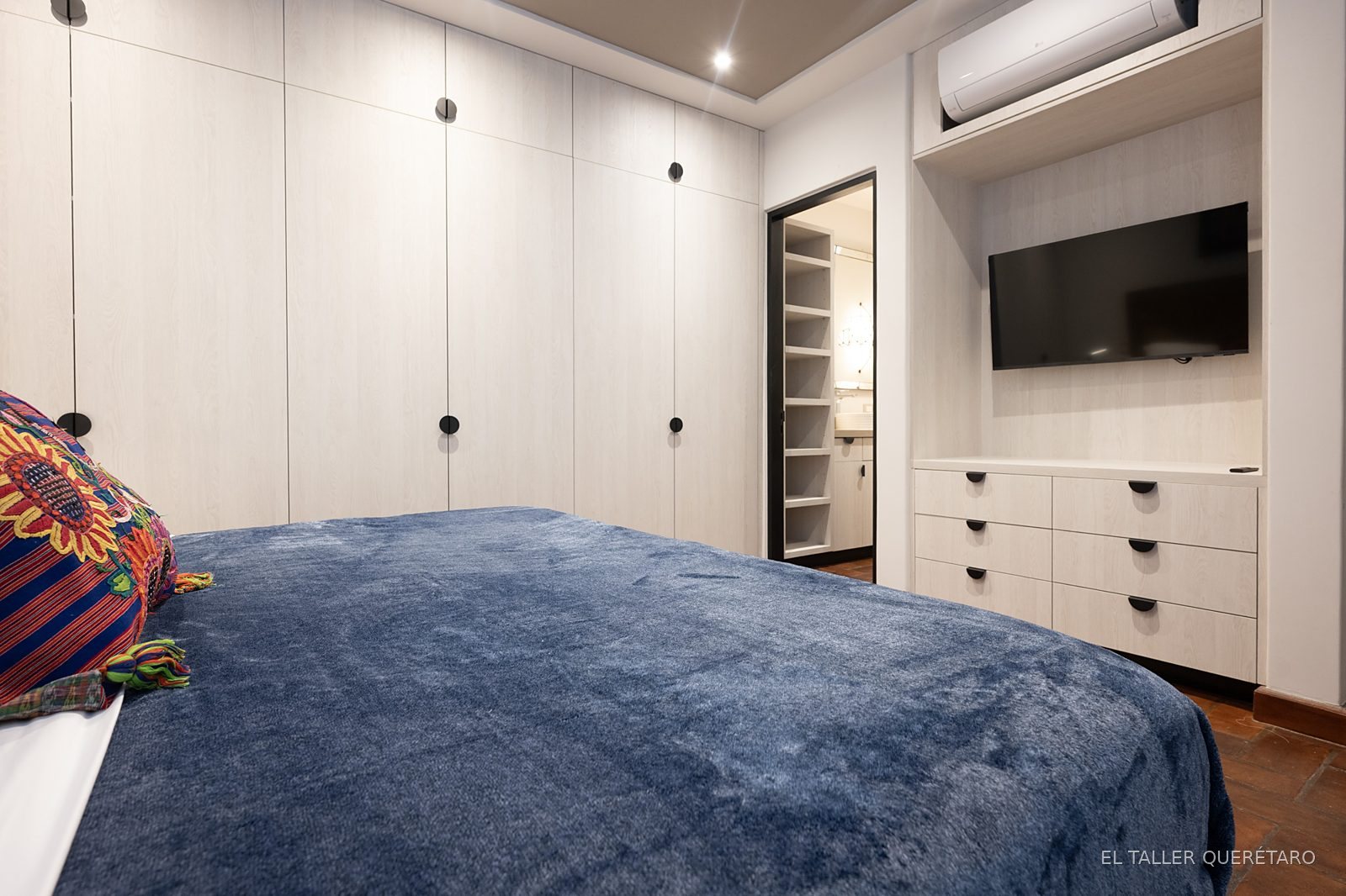 Recámara con closet de piso a techo y mueble de TV