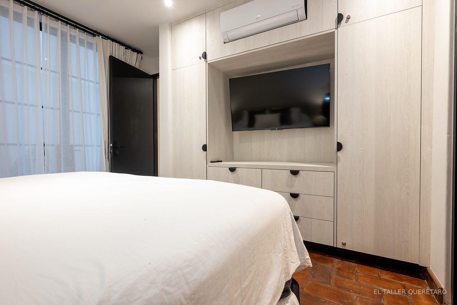 Recámara con mueble de TV y closet, vista general