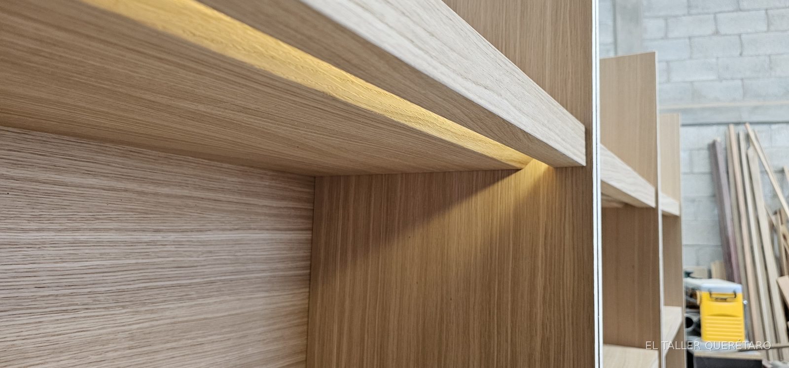 Detalle de entrepaño con luz LED integrada durante el armado en taller